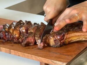 Découpe côte de bœuf gourmande cuite au feu de bois à la cheminée